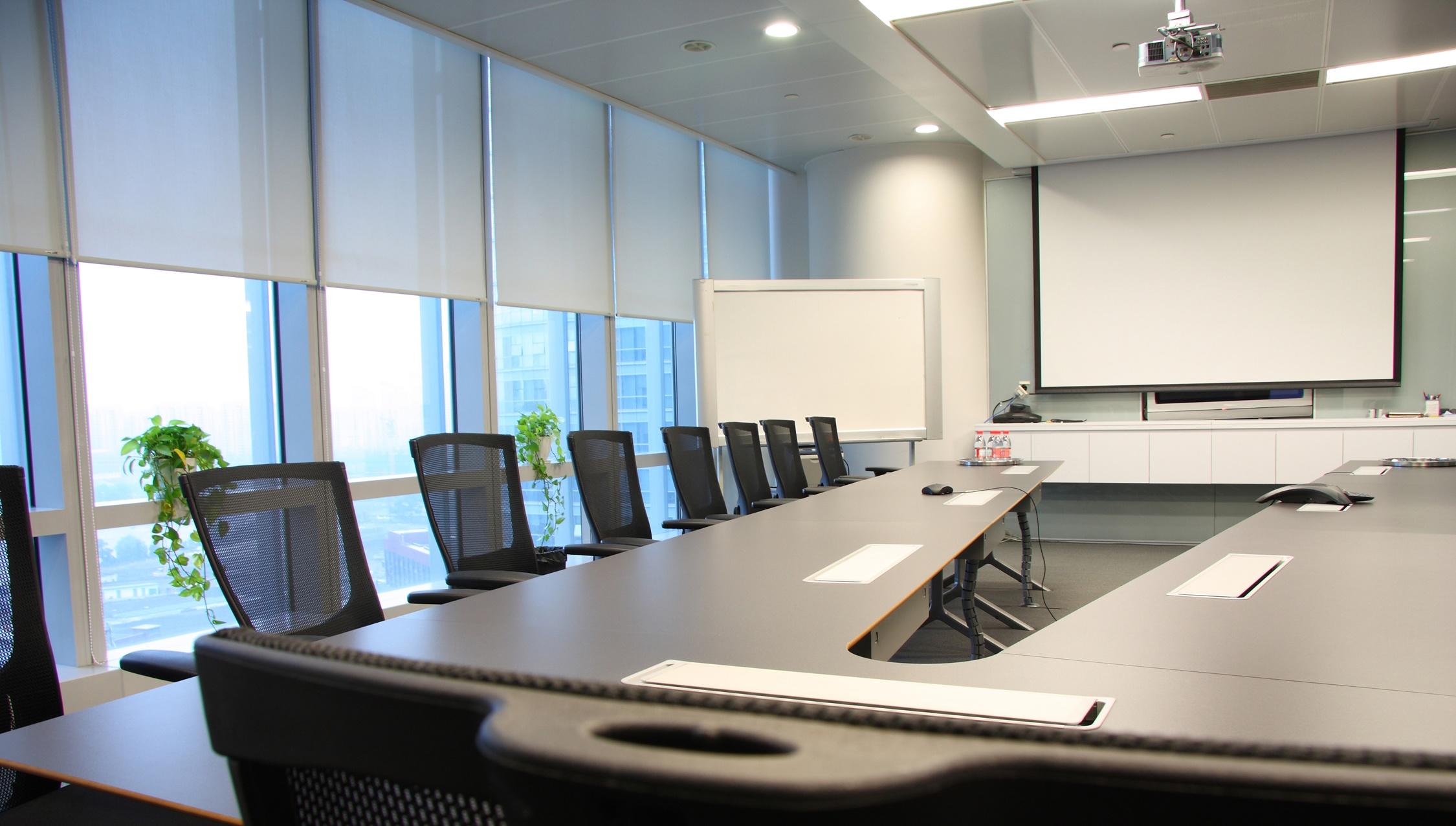 conference room with shade risen halfway and projector screen