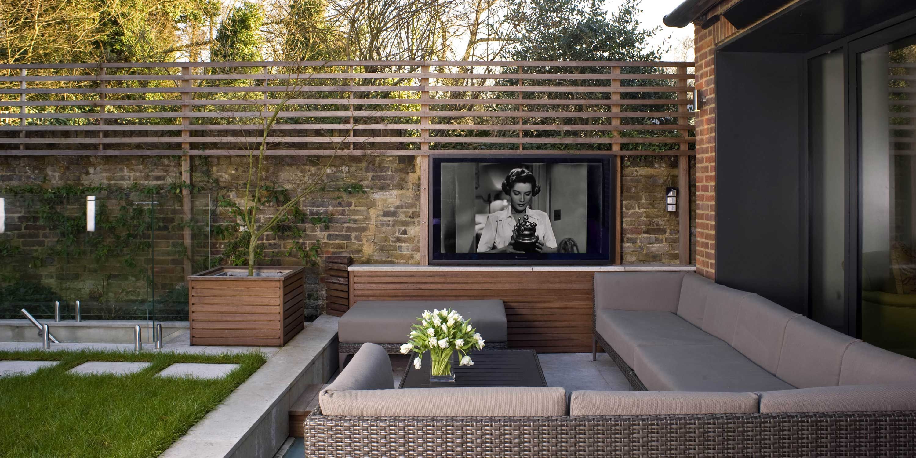 Outdoor seating area with a beige couch and technology from Future Automation